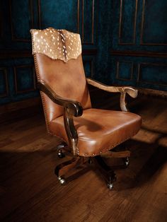 a brown leather chair sitting on top of a wooden floor next to a blue wall