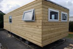 a small wooden house with windows and siding