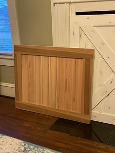 a wooden box sitting on top of a hard wood floor next to a white door