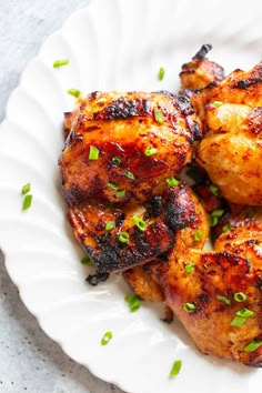 grilled chicken with green onions on a white plate