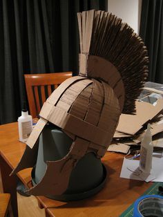 a cardboard helmet sitting on top of a wooden table