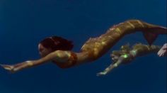 two mermaids are swimming in the water