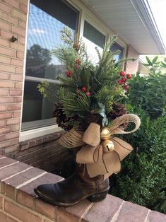 a boot with a christmas decoration on the side of it sitting in front of a window