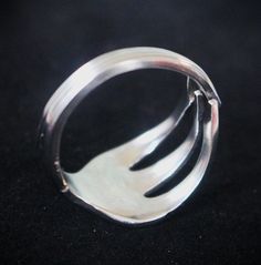 a close up of a silver ring on a black surface