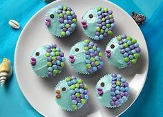 there are cupcakes that have been decorated to look like fish on the plate