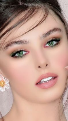 a woman with green eyes and white flowers in her hair is posing for the camera