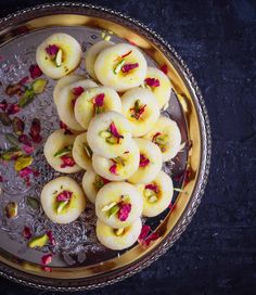 some kind of food that is on a metal plate with water and flowers around it