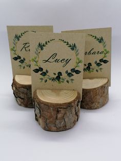 three place cards are sitting on wood slices