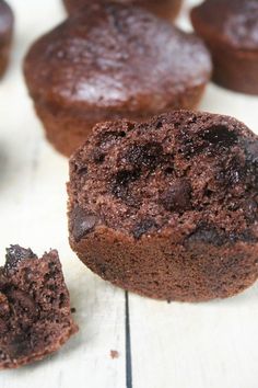 chocolate muffins on a table with one cut in half