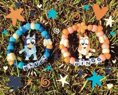 two bracelets with cartoon characters on them sitting in the grass next to each other