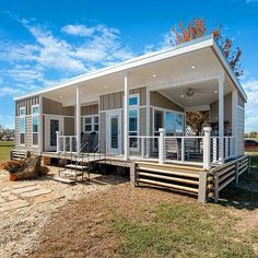 the tiny house is built on stilts and has porches