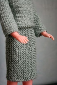 the doll is wearing a green knitted dress