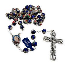 a rosary with a photo on it next to a blue and red beaded bracelet