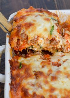 a casserole dish with meat and cheese being lifted from the casserole