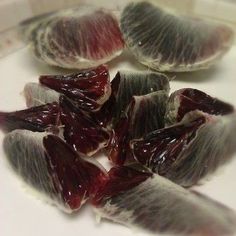 several pieces of fruit sitting on top of a white plate covered in jelly and blood