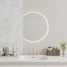 a bathroom with marble counter tops and white walls, along with a round mirror on the wall