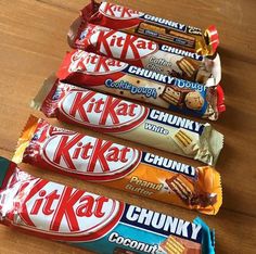 five candy bars lined up on a wooden table