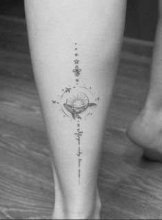 a black and white photo of a person's foot with a compass tattoo on it