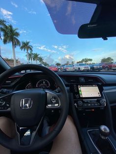 the interior of a car with dashboard, steering wheel and display screen showing cars parked in parking lot