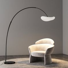 a modern floor lamp in the corner of a room with a white chair and grey walls