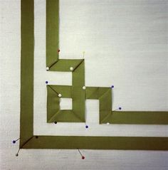 a piece of paper that has been cut into squares and pinned to the wall with pins