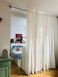 a bedroom with a bed and white curtains