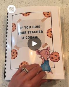 a person holding up a book with an image of a mouse on it and the title if you give your teacher a cookie