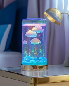 a night light with clouds and stars in it on a table next to a lamp