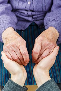 an elderly woman holding her hands together