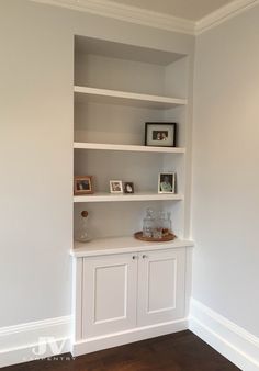 an empty white bookcase in the corner of a room with wood floors and hard wood flooring