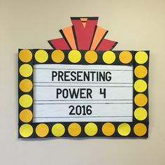 a sign that says presenting power 4 in front of a white wall with yellow and orange circles