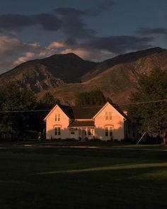 a white house with mountains in the background at sunset or dawn, near an intersection