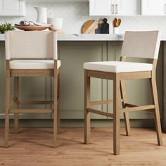 two stools in a kitchen next to a counter with utensils on it