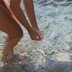 a person standing in the water with their feet up