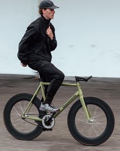 a man riding on the back of a green bike