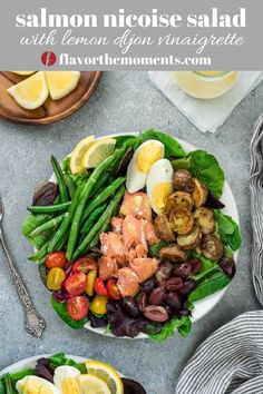 two plates filled with salmon, eggs and vegetables on top of a table next to silverware