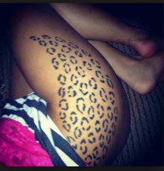 a woman's leg with a tattoo on it that has an animal print pattern