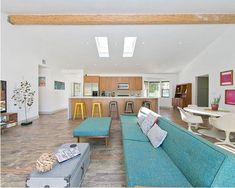 a living room filled with furniture next to a kitchen