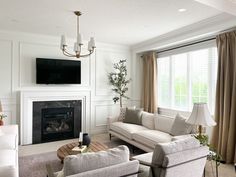 a living room filled with furniture and a flat screen tv mounted on the wall above a fireplace