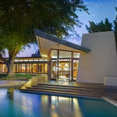 an outdoor swimming pool with steps leading up to it and trees in the background at night