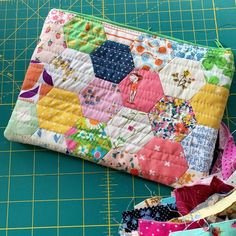 a patchwork purse sitting on top of a cutting board