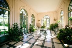 a room filled with lots of windows and plants