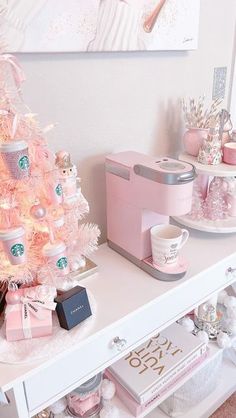 a white christmas tree with pink decorations and gifts on it's shelf next to a coffee maker