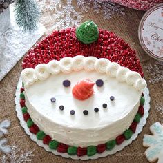 a decorated cake with frosting and icing on it sitting next to christmas decorations