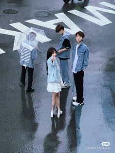 three children standing in the rain with an umbrella