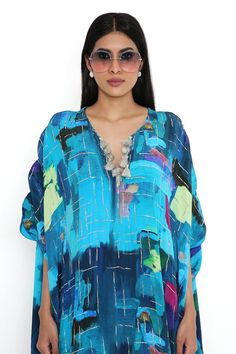 Dark blue kaftan with all over paint brush effect, highlighted with tasselled neckline.
Components: 1
Pattern: Print
Type Of Work: Paint Brush Effect
Neckline: Notched V Neck
Sleeve Type: Three Quarter Sleeves
Fabric: Crepe
Color: Blue
Other Details: 

 Length: 60 inches
Model height: 5ft 8inches, wearing size M
Disclaimer: Since the designer is a made-to-measure brand and the dyeing process and embroidery are handcrafted, there may be slight variations in the color and embroidery of the actual Blue Silk V-neck Kaftan, Blue Silk Tunic Kaftan, Spring Blue Kaftan With Tassels, Blue Kaftan With Tassels For Spring, Blue Tassel Kaftan For Spring, Blue Silk Summer Kaftan, Blue Ikat Print Kaftan For Summer, Summer Blue Ikat Print Kaftan, Blue Festive Kaftan For Vacation