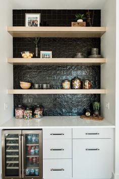 a kitchen with white cabinets and shelves filled with food