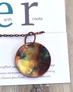 This boho style minimalist necklace features a pendant designed from a copper disc 1" in diameter that has been shaped and fire painted with a propane torch to bring out the different colors in the metal when heated. NOTE:  Certain lighting will bring the colors out more than other types of lighting. It comes with a 16" copper chain and will ship in a gift box with USPS tracking info  provided. Minimalist Hammered Copper Jewelry, Artsy Hand Forged Copper Jewelry, Hand Forged Copper Round Pendant Necklace, Mystical Silver-colored Copper Necklace, Bronze Copper Necklace With Patina, Mystical Silver-plated Copper Necklace, Oxidized Copper Pendant Necklace, Spiritual Patina Copper Necklace, Fire Painting