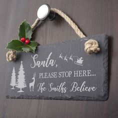 a slate sign that says santa, please stop here the smiths believe