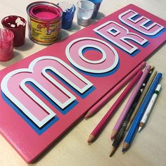 a pink sign with the word omo painted on it next to some crayons